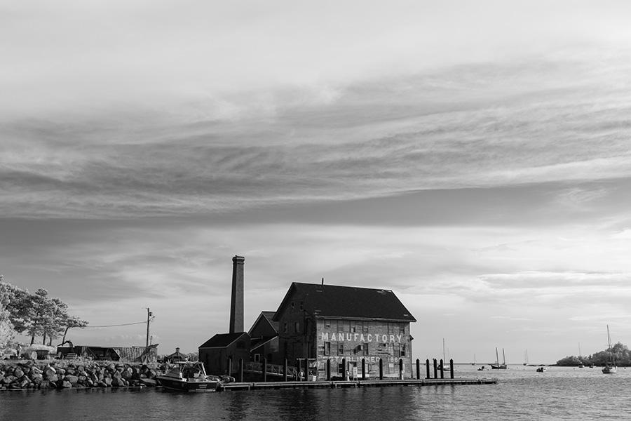 Infrared Photo of Factory Building On Waterfront with Dramatic Sky.